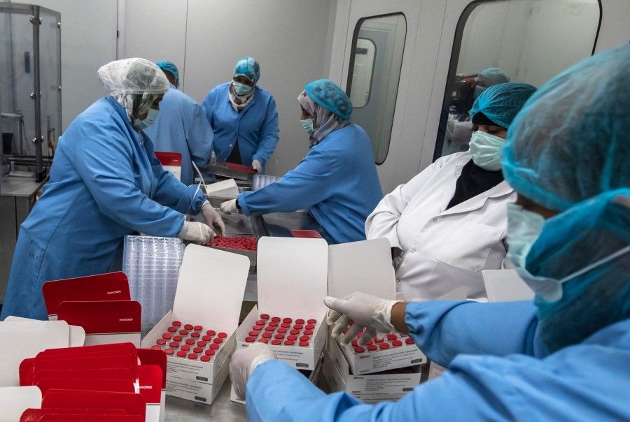 Laboratory workers fill boxes with vials of China's Sinovac vaccine against the coronavirus, produced by the Egyptian company VACSERA, in Cairo on 1 September 2021. (Photo by Khaled Desouki/AFP)