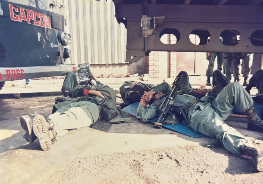 Soldiers rest on the ground after a prolonged standoff between government and rebel forces.