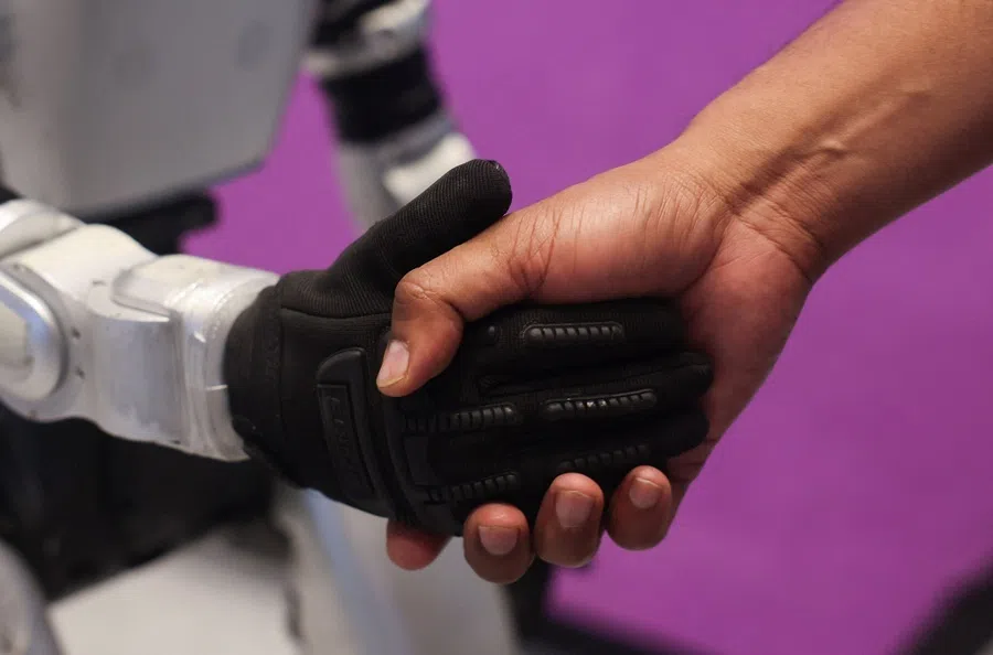 A man shakes the hand of a Chinese G1 humanoid robot made by Unitree Robotics at the ImagiNxt conference in Mumbai, India, on 22 May 2026.