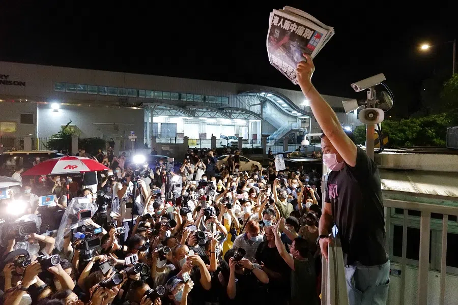 An Apple Daily journalist holds freshly printed copies of the newspaper's last edition to be distributed to supporters gathered outside their office in Hong Kong, China, early on 24 June 2021. (Daniel Suen/AFP)