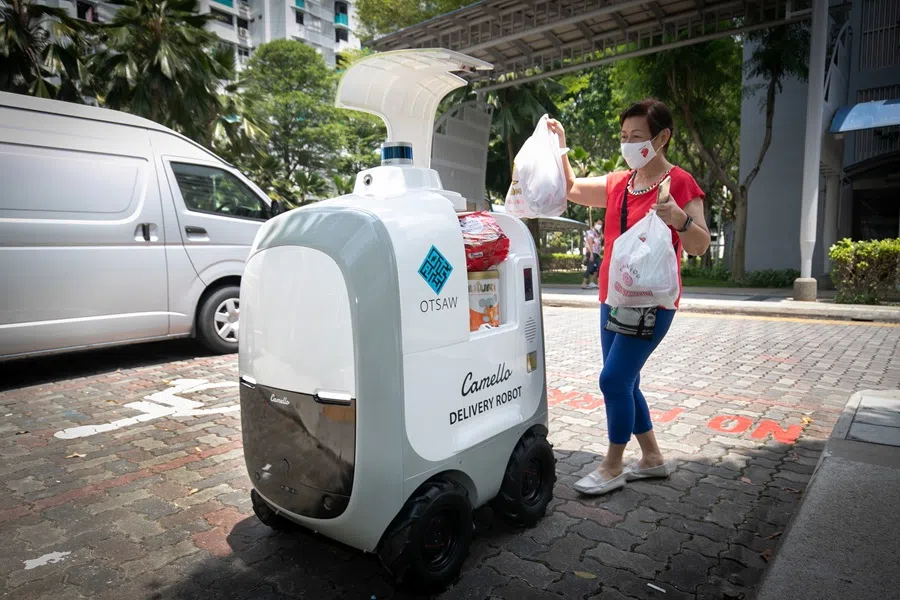 Technology company OTSAW piloted robot “deliverymen” in residential areas with a high proportion of elderly residents, helping seniors who are unable to lift heavy items to deliver their purchased daily necessities to the ground floor of their residential blocks, April 2021. (SPH Media)