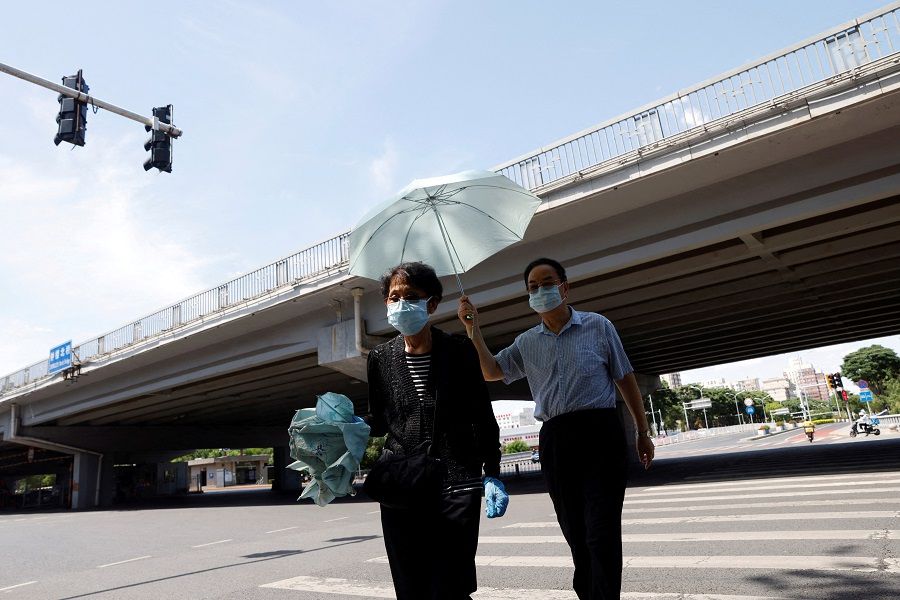 People cross a road amid the Covid-19 outbreak in Beijing, China, 25 May 2022. (Carlos Garcia Rawlins/File Photo/Reuters)