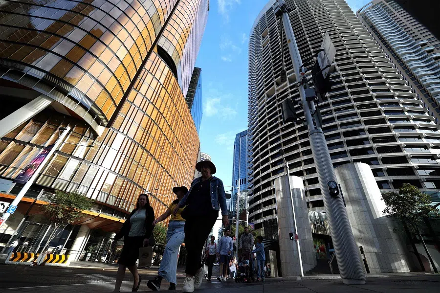 This picture taken on 15 April 2025 shows people walking among the high-rise buildings in Sydney’s central business district at the end of office hours. (Saeed Khan/AFP)