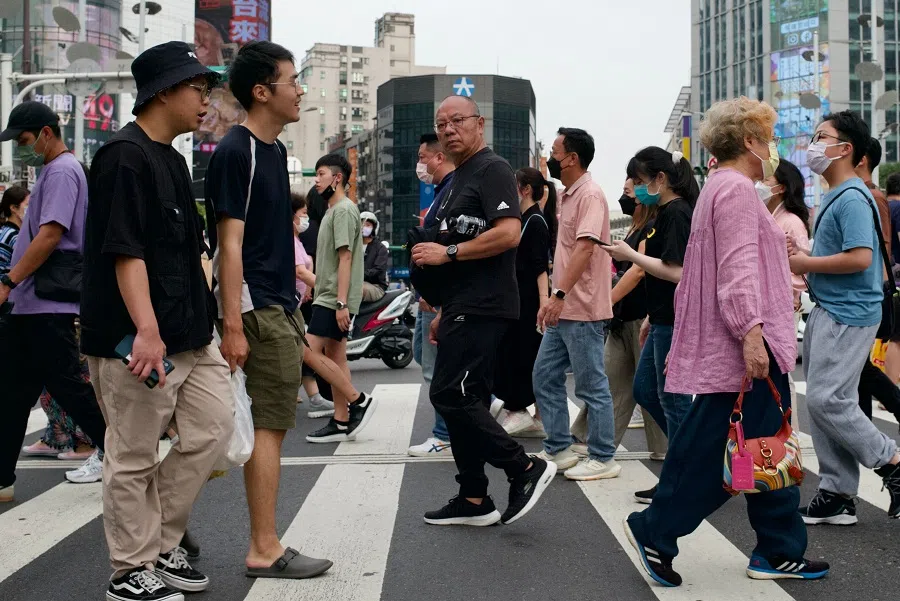 This picture taken on 14 April 2023 shows people walking down a street at the Ximen district in Taipei, Taiwan. (Sam Yeh/AFP)