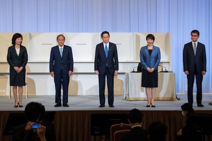 Fumio Kishida (centre) stands on the stage with outgoing Prime Minister Yoshihide Suga and fellow candidates, Seiko Noda, Sanae Takaichi and Taro Kono after winning the Liberal Democrat Party leadership election in Tokyo, Japan, 29 September 2021. (Carl Court/Pool via Reuters)