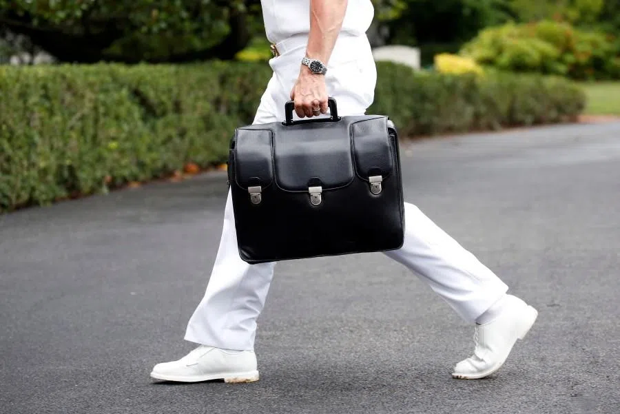 A military aide carries a briefcase containing launch codes for nuclear weapons as US President Donald Trump returns to the White House in Washington, US, on 24 July 2018. (Joshua Roberts/Reuters)
