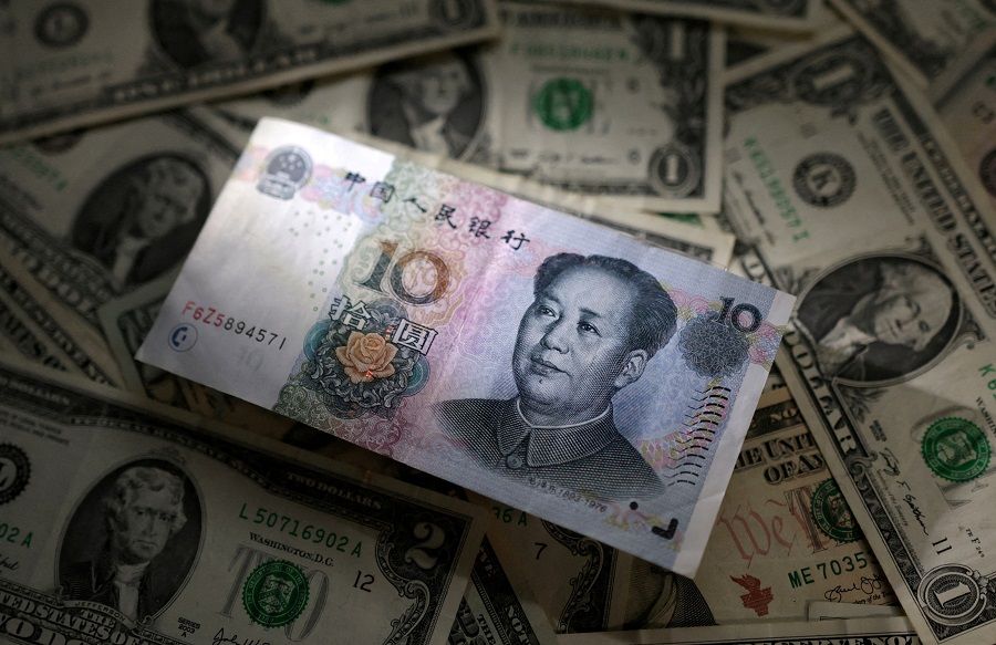 Chinese RMB and US dollar banknotes are seen in this illustration taken 10 March 2023. (Dado Ruvic/Illustration/Reuters)