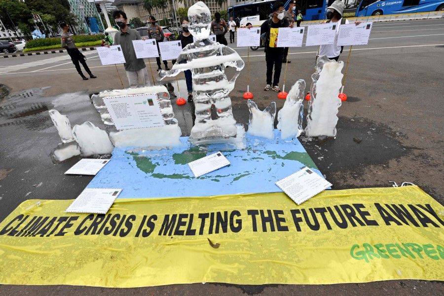 Activists from Greenpeace Indonesia take part in a rally with an ice-made effigy and postcards to Indonesian President Joko Widodo calling for action on climate change in Jakarta on 10 November 2021, as world leaders attend the COP26 UN Climate Change Conference in Glasgow. (Adek Berry/AFP)