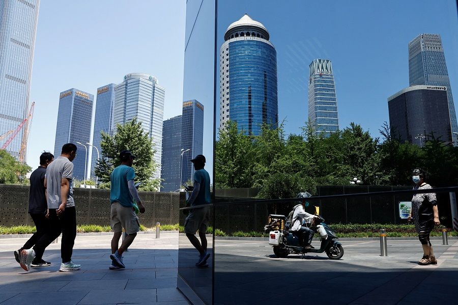 People walk past the central business district, in Beijing, China, on 21 June 2023. (Tingshu Wang/Reuters)