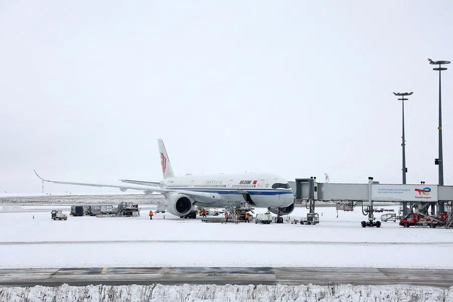 An Air China plane is seen on the snow-covered tarmac at Terminal 1 of the Paris-Charles de Gaulle Airport, in Roissy-en-France, near Paris, France, 7 January 2026. (Abdul Saboor/Reuters)