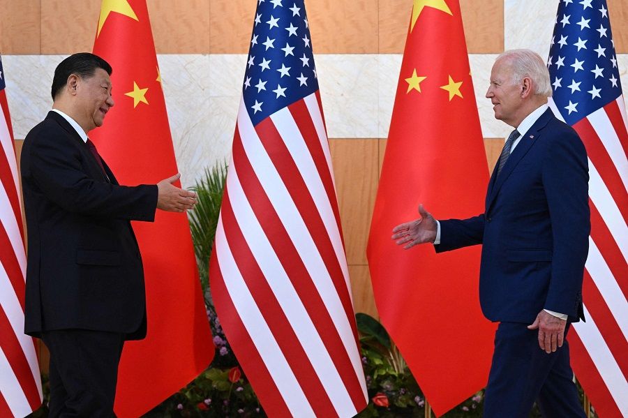 US President Joe Biden (right) and Chinese President Xi Jinping walk to shake hands as they meet on the sidelines of the G20 Summit in Nusa Dua on the Indonesian resort island of Bali on 14 November 2022. (Saul Loeb/AFP)
