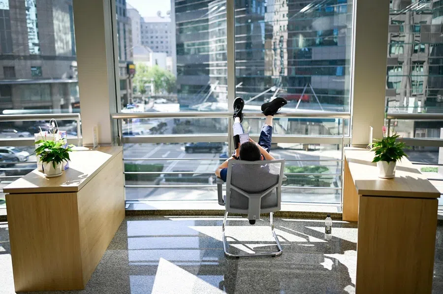 A man uses his mobile phone as he takes a break in an office building in Beijing on 14 September 2026.