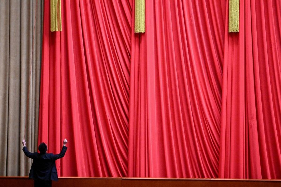 A staff member works inside the Great Hall of the People ahead of the closing session of the National People's Congress (NPC) in Beijing on 13 March 2023. (Noel Celis/Pool via Reuters)