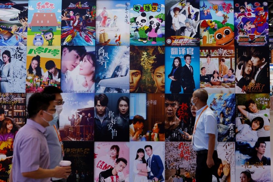 People walk past a display of posters for Chinese movie and television productions at the 2021 China International Fair for Trade in Services (CIFTIS) in Beijing, China, 4 September 2021. (Florence Lo/Reuters)