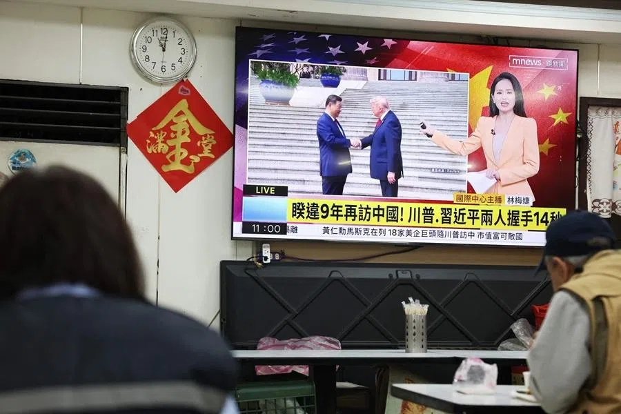A television news programme at a restaurant in Taipei on 14 May 2026 shows the meeting between the US President Donald Trump and China's President Xi Jinping in Beijing. (I-Hwa Cheng/AFP)