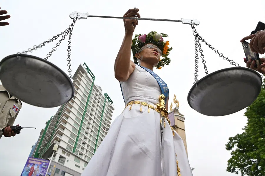 Theary Seng, a US-Cambodian lawyer and activist who is facing treason and incitement charges, poses in front of Phnom Penh Municipal Court ahead of her hearing in Phnom Penh, Cambodia, on 3 May 2022. (Tang Chhin Sothy/AFP)