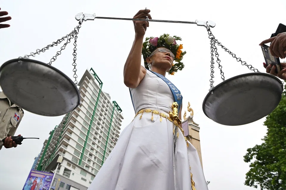 Theary Seng, a US-Cambodian lawyer and activist who is facing treason and incitement charges, poses in front of Phnom Penh Municipal Court ahead of her hearing in Phnom Penh, Cambodia, on 3 May 2022. (Tang Chhin Sothy/AFP)