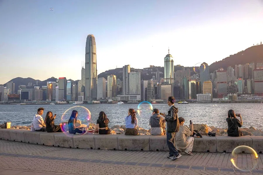 People at a promenade next to Victoria Harbour in Hong Kong, China, on 18 January 2024. (Dale de la Rey/AFP)