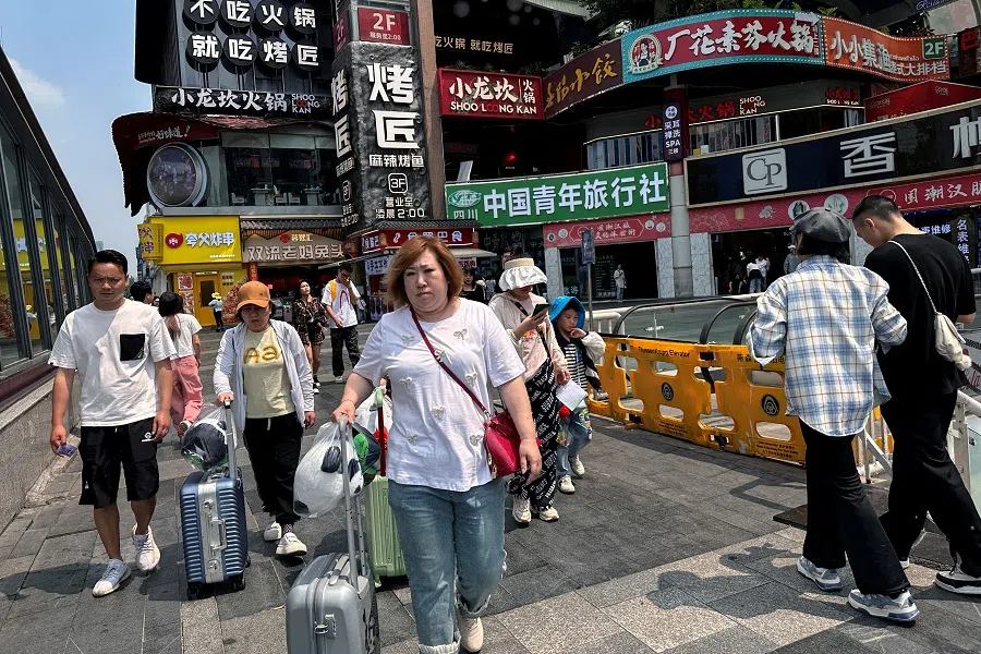 People walk at a restaurant complex in Chengdu, Sichuan province, China, on 13 April 2024. (Tingshu Wang/Reuters)