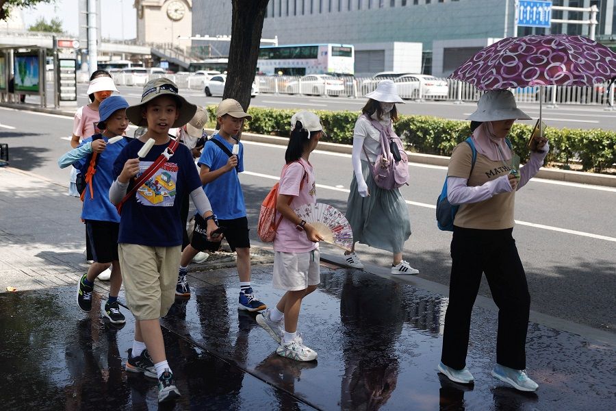 Children eat ice cream in Beijing, China, on 5 July 2023. (Tingshu Wang/Reuters)