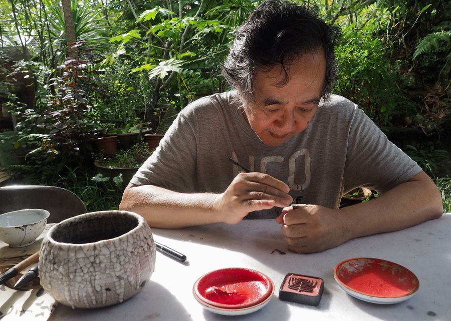 Artist Oh Chai Hoo working on a seal carving.