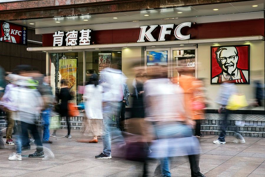 Pedestrians walk past a KFC restaurant in Shanghai, China, on 21 October 2015. (Qilai Shen/Bloomberg)