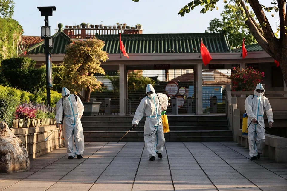 This photo taken on 6 October 2021 shows staff members spraying disinfectant at Gulangyu as the island prepares to reopen to tourists after being closed due to the outbreak of the Covid-19 coronavirus, in Xiamen, Fujian province, China. (STR/AFP)