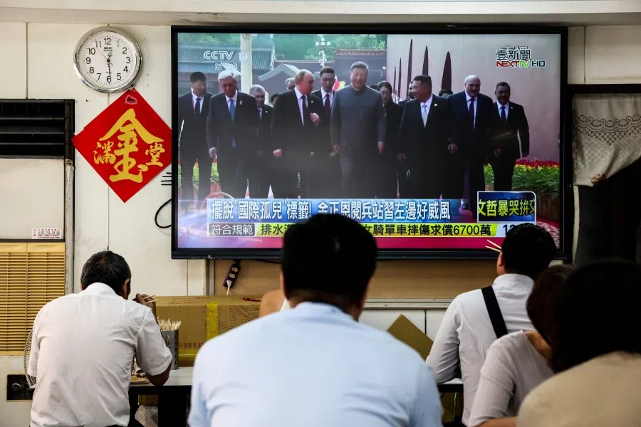 People watch a television showing Chinese President Xi Jinping with North Korean leader Kim Jong Un and Russian President Vladimir Putin during a military parade that took place in Beijing on 3 September 2025, marking China’s 80th anniversary of victory over Japan and the end of World War II, in Taipei on 4 September 2025. (I-Hwa Cheng/AFP)