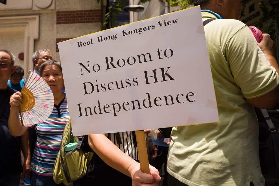 A member of pro-government group 'Real Hong Kongers View' holds a placard that reads "No Room to Discuss HK Independence" during a gathering outside the Foreign Correspondents' Club (FCCHK) in Hong Kong on 8 August 2018. (Anthony Wallace/AFP)