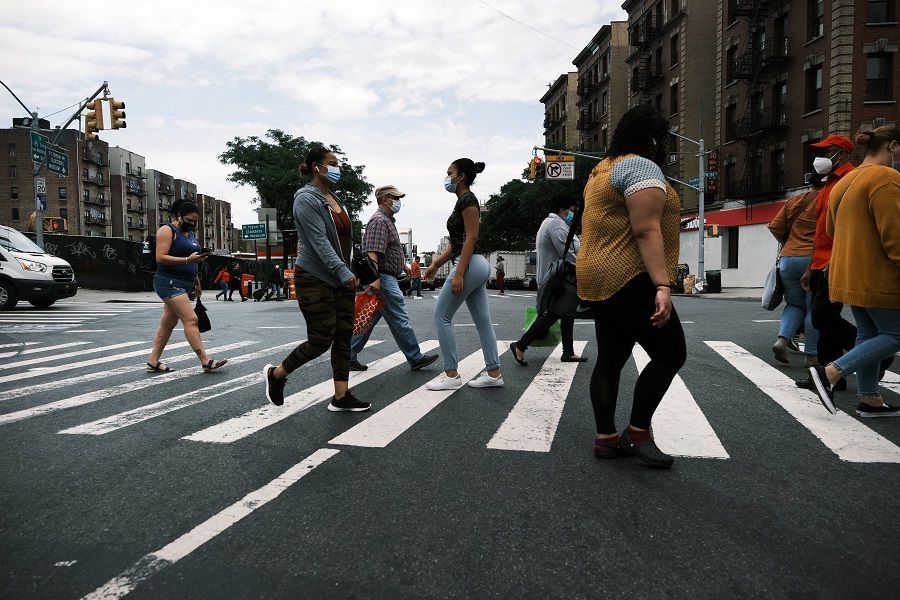 People walk through the Washington Heights neighborhood in Manhattan on 11 June 2021 in New York City, US. (Spencer Platt/Getty Images/AFP)