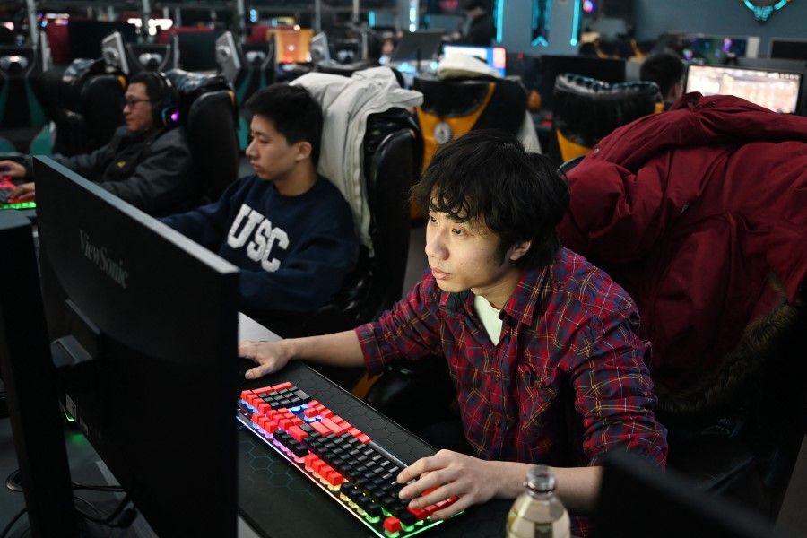 People play computer games at an internet cafe in Beijing on 26 January 2024. (Greg Baker/AFP)