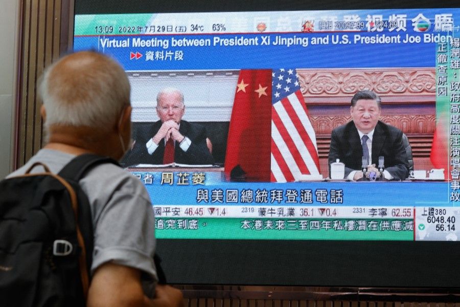 A screen displays images of Chinese President Xi Jinping and US President Joe Biden, while broadcasting news about their recent call at a shopping mall in Hong Kong, China, 29 July 2022. (Tyrone Siu/Reuters)