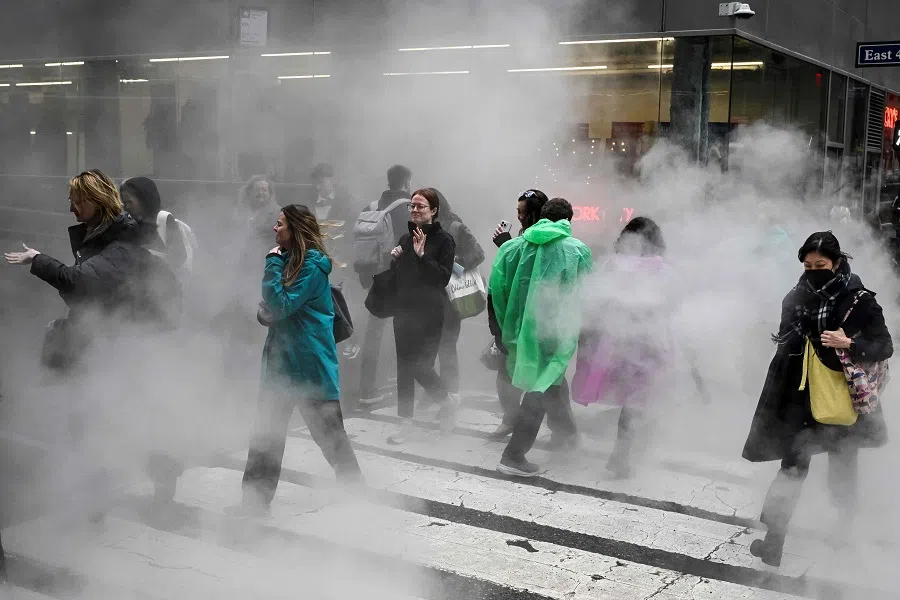 People walk through steam on a rainy day on 24 March 2025 in New York City. (Angela Weiss/AFP)