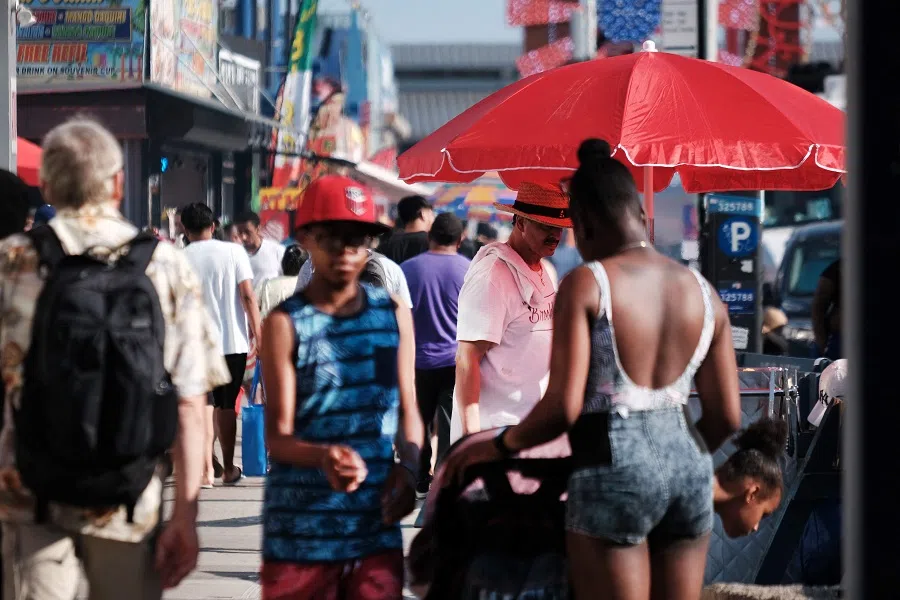 People walk on a busy street in Coney Island on 6 July 2023 in the Brooklyn borough of New York City, US. (Spencer Platt/Getty Images/AFP)