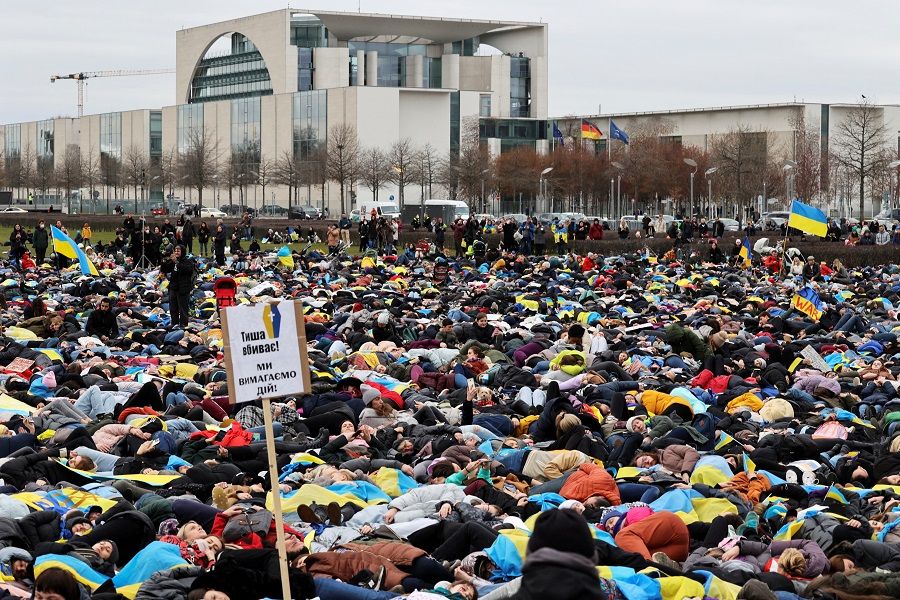 People lay down during a "die-in" protest outside of the Reichstag building, depicting the posture of civilians found dead in the streets of the Ukraine town of Bucha, as Russia's invasion of Ukraine continues, in Berlin, Germany, 6 April 2022. A banner reads "Silence kills. We demand actions". (Christian Mang/Reuters)