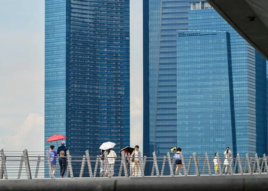 People walk across Jubilee Bridge at Marina Bay in Singapore on 5 May 2026. (Roslan Rahman/AFP)