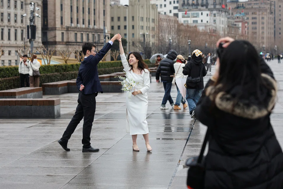A couple pose during a photoshoot session on the Bund in Shanghai, China, on 14 February 2025. (Go Nakamura/Reuters)