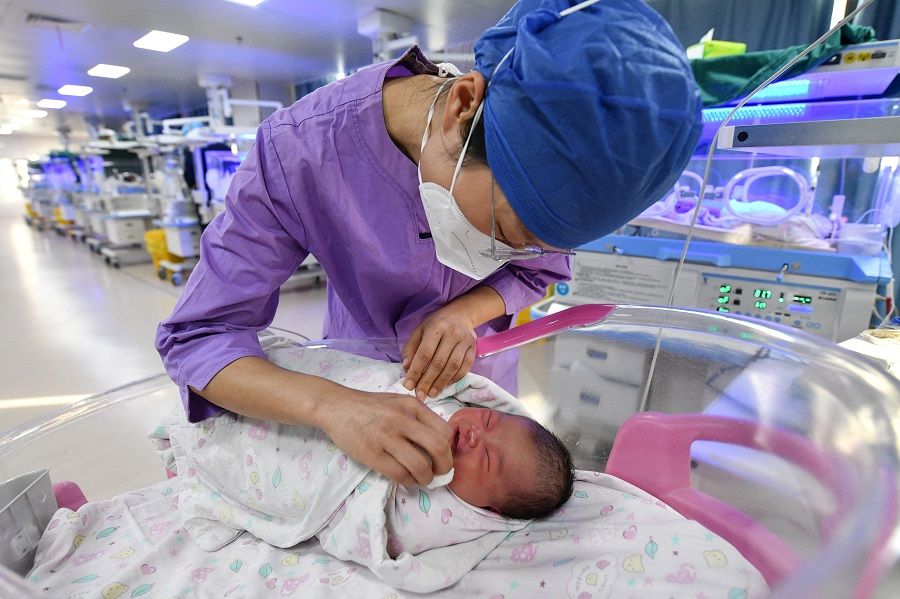 A nurse takes care of a newborn baby at a hospital in Fuyang, Anhui province, China, on 17 January 2023. (AFP)