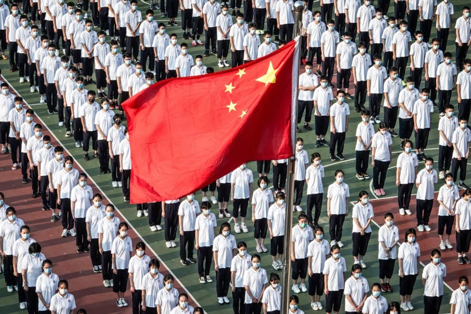 This aerial photo taken on 1 September 2021 shows students attending the opening ceremony on the first day of the new semester in Wuhan in China's central Hubei province. (STR/AFP)