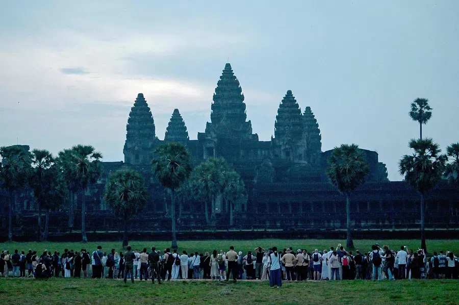 Tourists gather in front of a pond as they wait to take pictures at sunrise at the Angkor Wat temple complex in Siem Reap province on 18 September 2024.