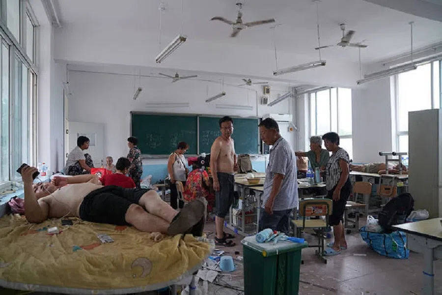 Evacuated people rest in a classroom in a middle school in Zhuozhou on 2 August 2023.