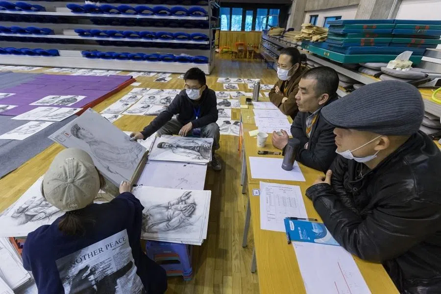 Teachers from the China Academy of Art view the sketches completed by Chinese students who took part in the National College Entrance Examination for art majors at a gymnasium in Hangzhou, Zhejiang province, China, 17 March 2019.