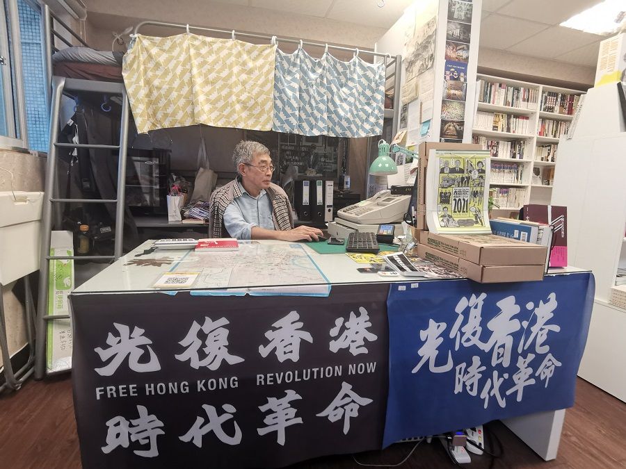 Lam Wing-kee in his bookstore that doubles up as his living space. A metal bunk bed can be seen behind him.
