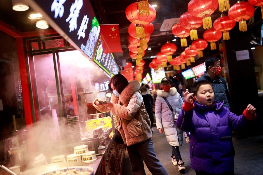 People walk in a historic part of Beijing as China celebrates Lunar New Year, China, 14 February 2021. (Thomas Peter/Reuters)