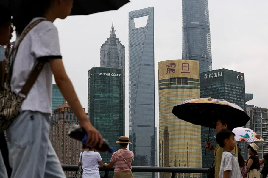 People walk on the Bund promenade in Shanghai, China, on 18 July 2025. (Go Nakamura/Reuters)