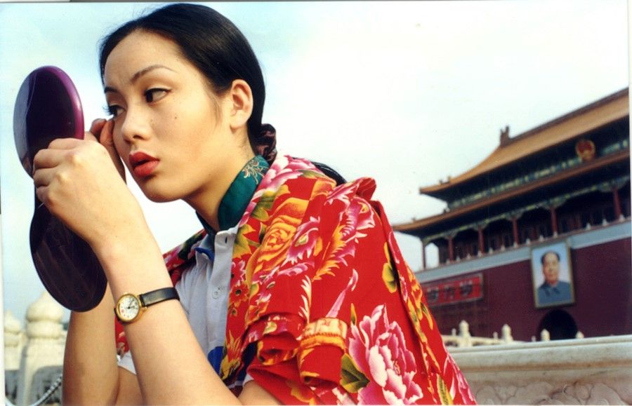 A Chinese model puts on makeup with the Tiananmen city wall in the background, 1998.