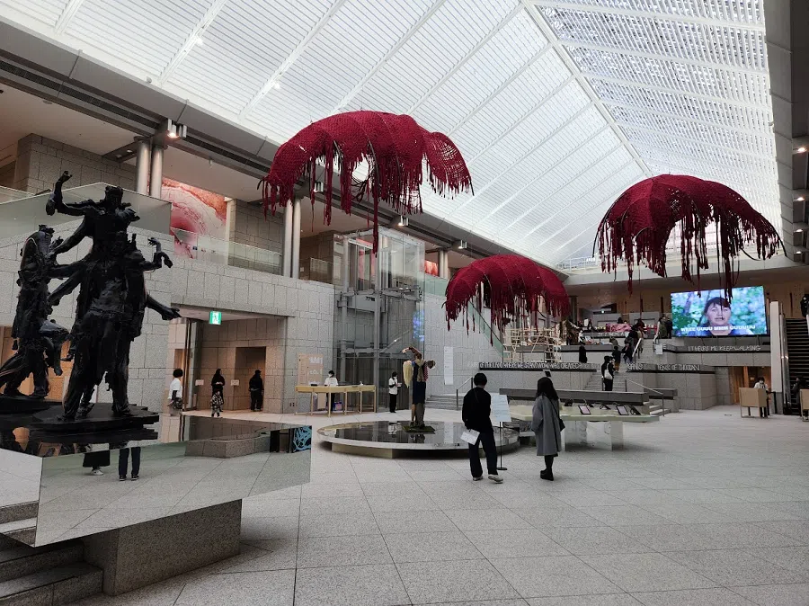The grand hall of the Yokohama Museum of Art. On the left is Miles Greenburg’s Mars (2022), and hanging from the ceiling are Sandra Mujinga’s suspended textiles.
