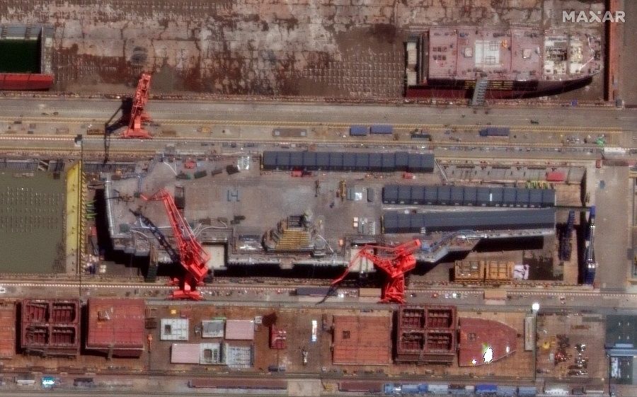 This handout satellite image taken by Maxar Technologies on 31 May 2022 shows a view of the Fujian, China's third aircraft carrier, under construction at the Jiangnan shipyard in Shanghai. (Satellite image ©2022 Maxar Technologies/AFP)