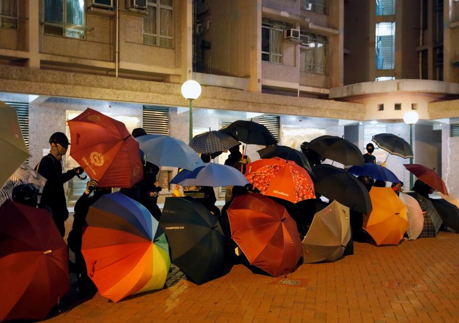 Anti-government protesters shield themselves with umbrellas during a protest in Hong Kong on 8 January 2020. (Navesh Chitrakar/Reuters)