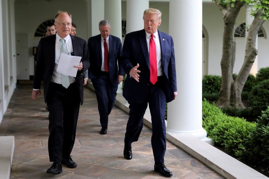 US President Donald Trump talks with Reuters White House correspondent Steve Holland as they walk down the West Wing colonnade with White House Chief of Staff Mark Meadows before an interview with Reuters in the Oval Office of the White House in Washington, DC, 29 April, 2020. (Carlos Barria/REUTERS)